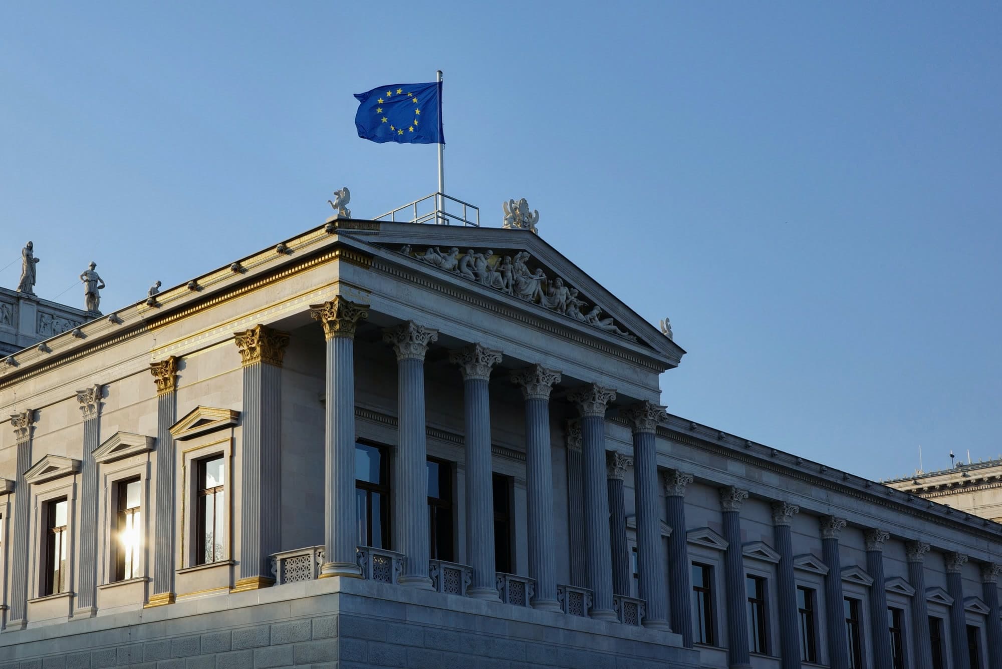 Trader monitoring digital asset markets with EU flag reflected in the window